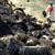 A clean up worker walks pass oil slicked rocks on the shore of Burrard Inlet Thursday afternoon. Thousands of litres of crude oil ruptured from a pipeline spill into the inlet Tuesday afternoon.